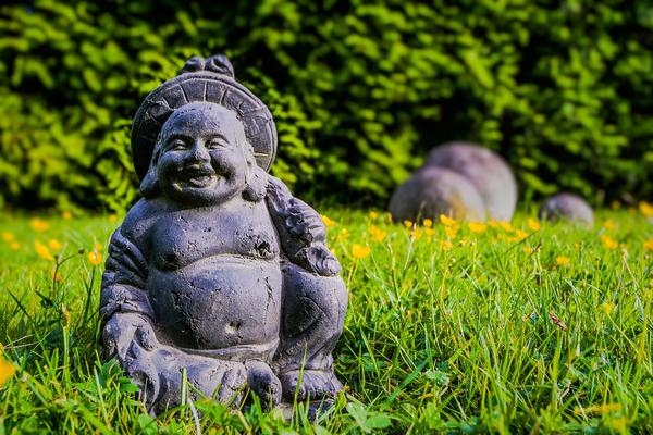 Laughing Buddha Statue with yellow flowers