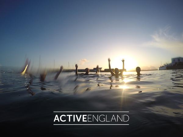 Swimmers waving in sea at dawn