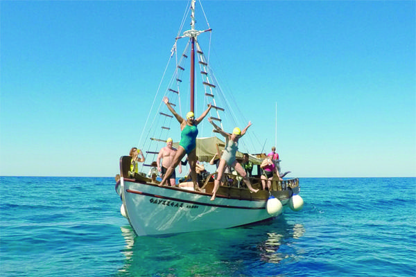 Big Blue Swim advert featuring women in swimsuits jumping off a boat into a blue sea