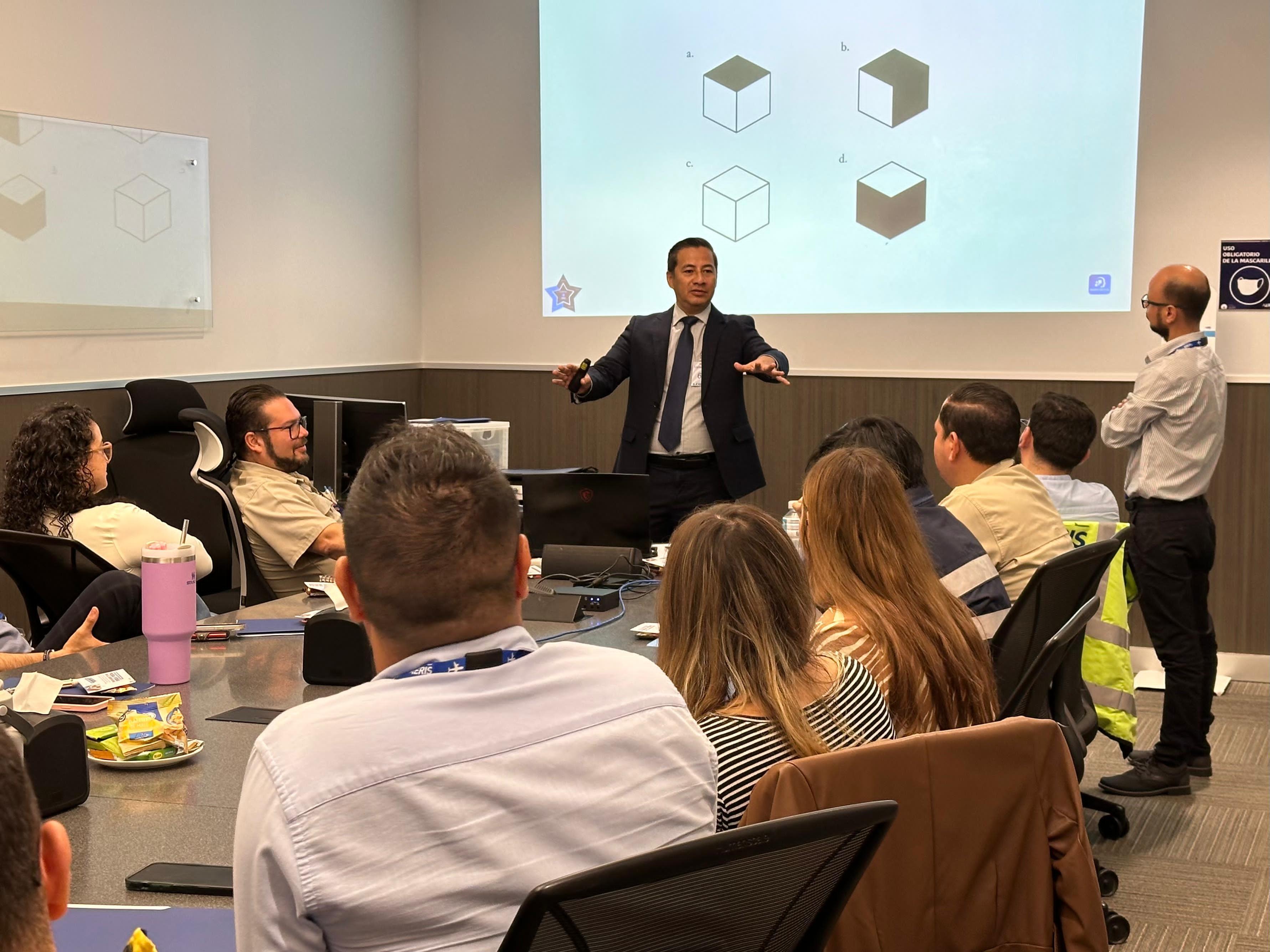 Dr. Eduardo Gómez Aguilar facilitando una capacitación frente a un equipo de trabajo