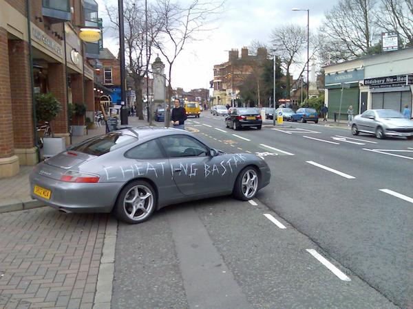 Porsche with "cheating bastard" written on the side