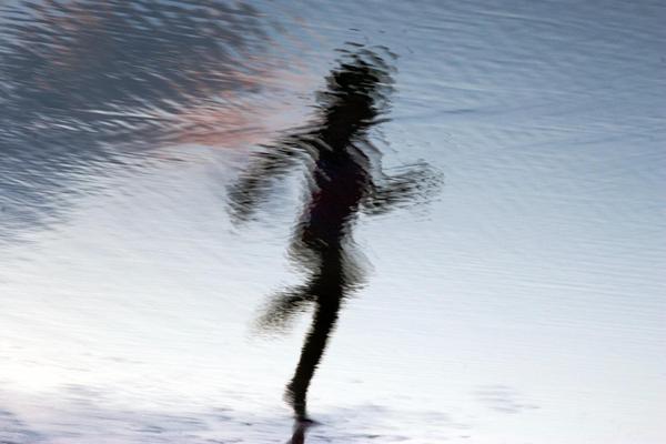 A blurry image of a person running at the beach.