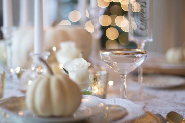 A decorated table with a cocktail glass and a white pumpkin