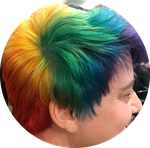 A person viewed from the side so you can see their short colorful rainbow pride hair. 