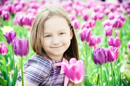 Girl sitting in a field of tulips
