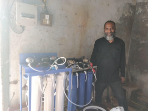 Peter Devassy in India with water purification tanks