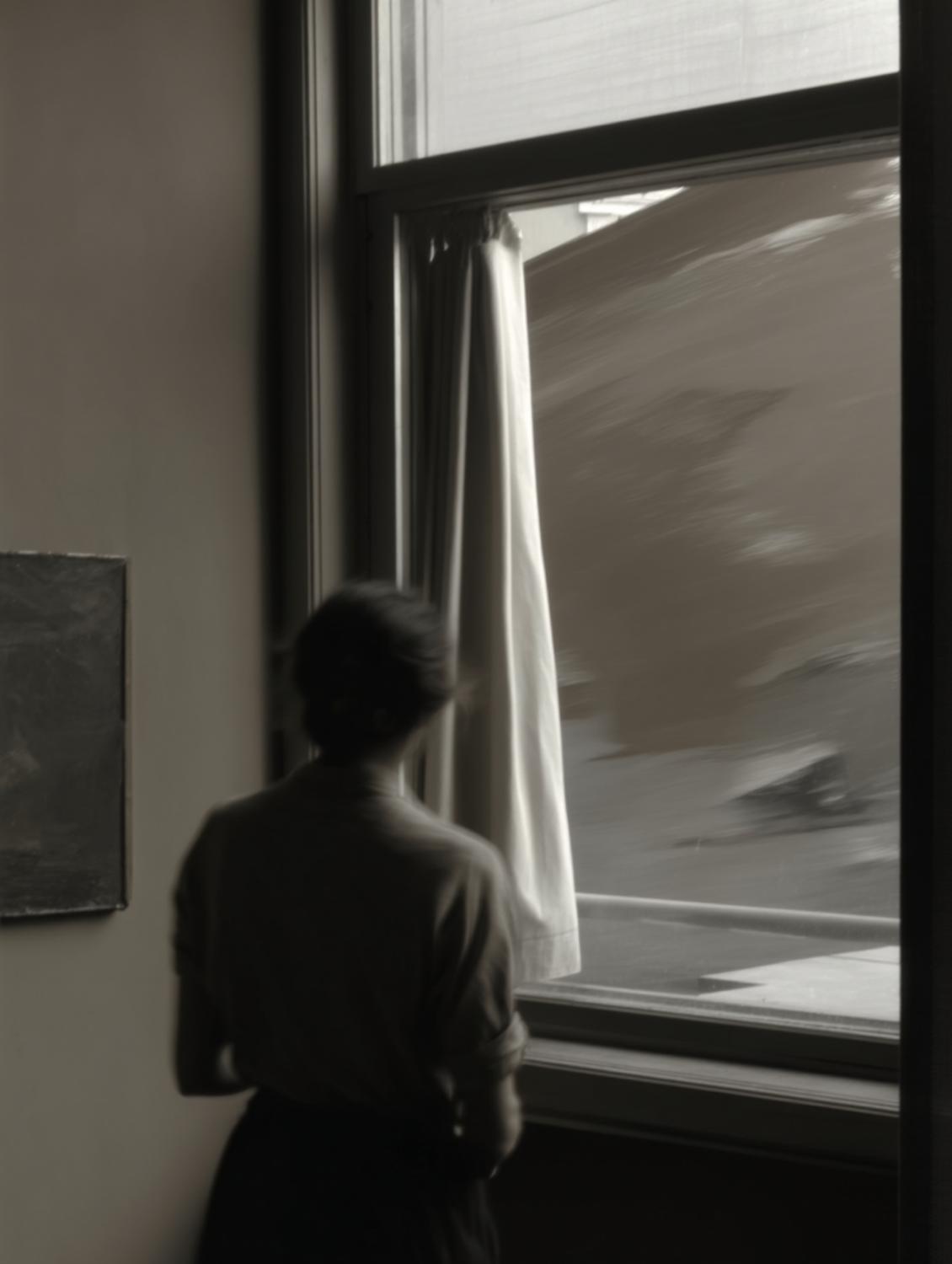 A person standing quietly by a window, reflecting on how their life feels right now