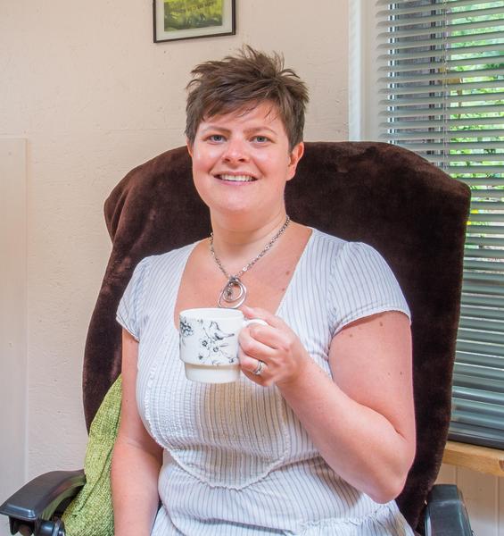 Zoe Thompson, smiling with cup of tea