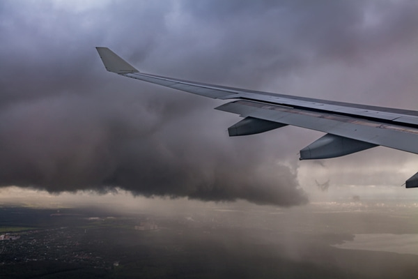 Dark stormy clouds and airplane wing