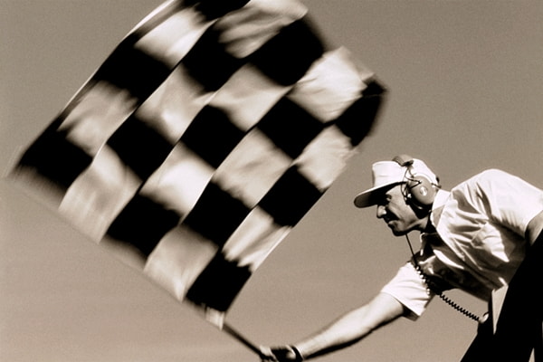Checkered race flag being swung down