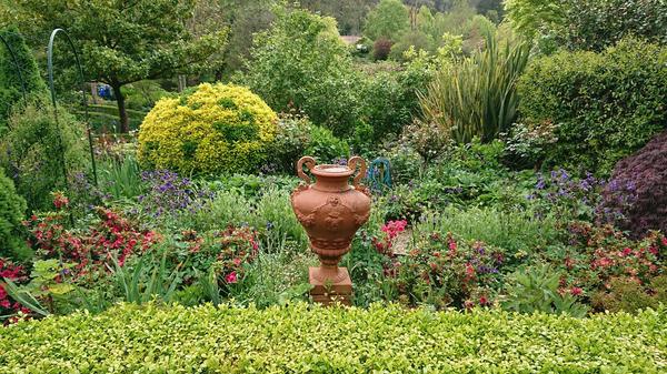 A garden bed with a pottery urn