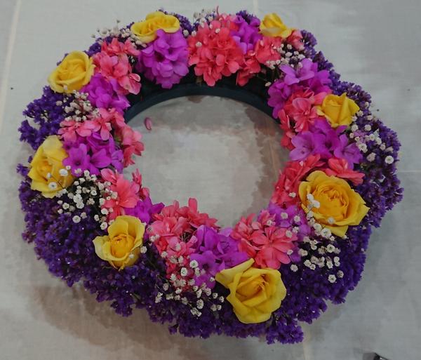 Wreath with yellow roses and coral, mauve, purple and white additional flowers