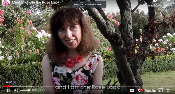 The Rose Lady in front of the rose garden