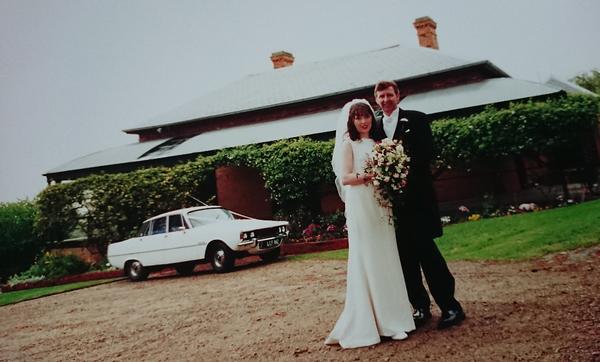Bride and groom and bridal car in front of Briars homestead