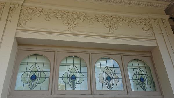 The Art Noveau botanical detailing and stained glass windows
