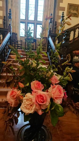 an arrangement of roses in front of the staircase