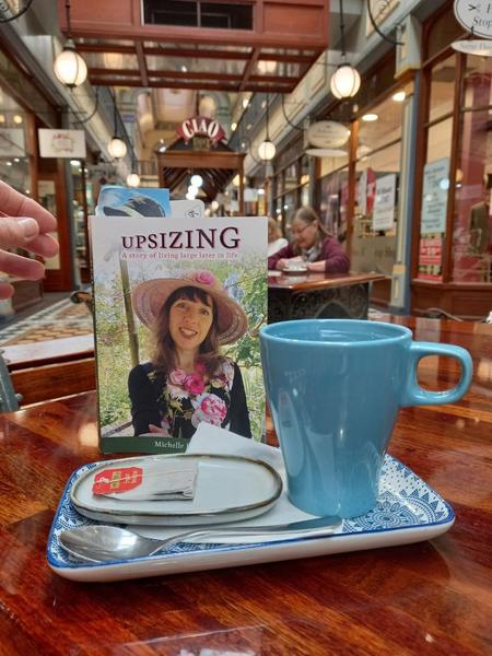 Upsizing book and a cup of tea in a cafe
