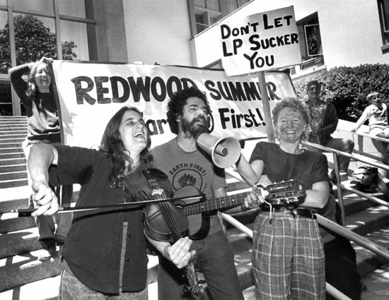 Judi Bari, environmentalist, feminist, labor organizer, and musician, plays the fiddle at a rally gearing up for Redwood Summer with colleague Darryl Cherney 