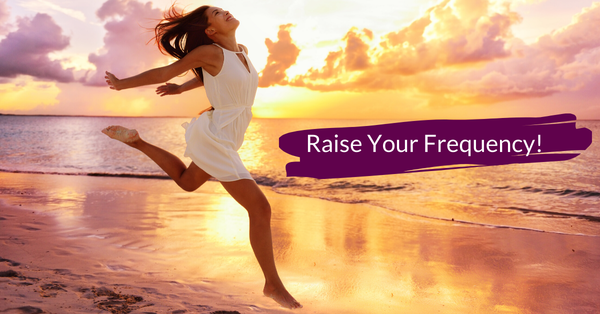 Woman on the beach in a white dress jumping in exhilaration. 