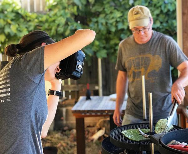 Holly photographing Hank grilling nopales