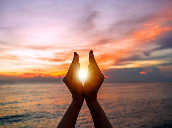 Hands framing the sun on Solstice. 