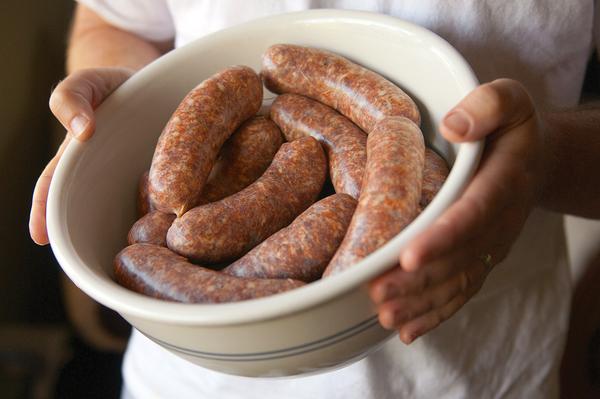 Hank Shaw holding a bowl of freshly made sausages.