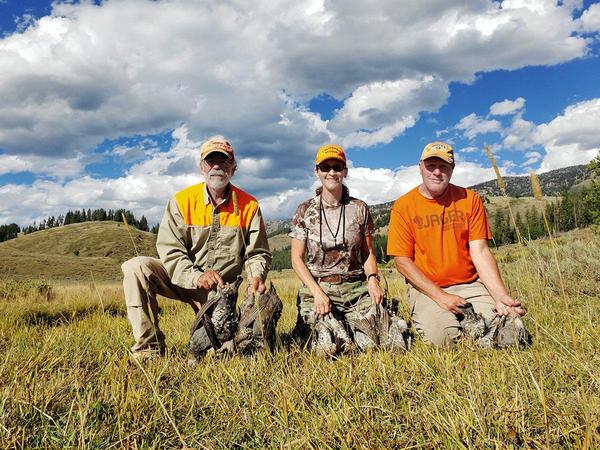 Three hunters with ruffed and dusky grouse