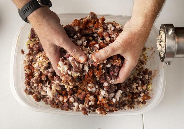 Hands mixing sausage ingredients