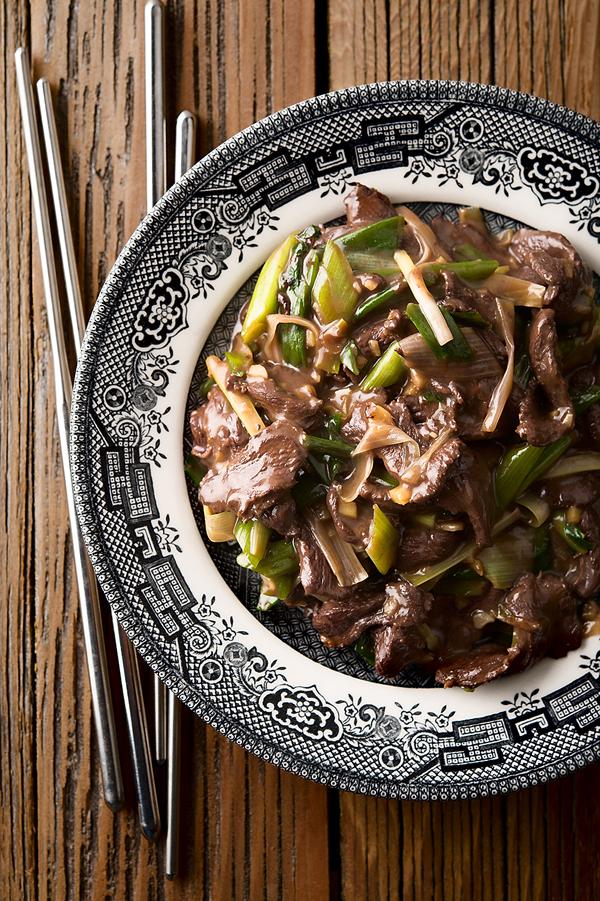 Duck stir fry with scallions on a plate. 