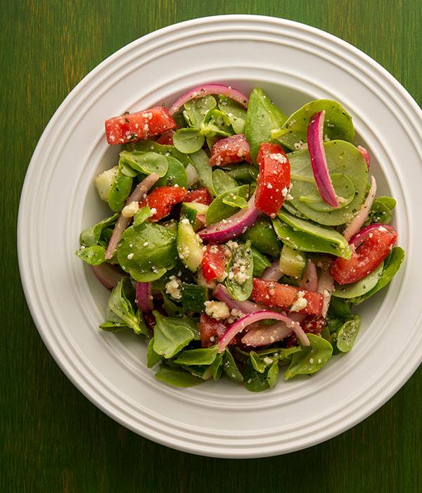 Purslane salad with tomatoes on a plate. 