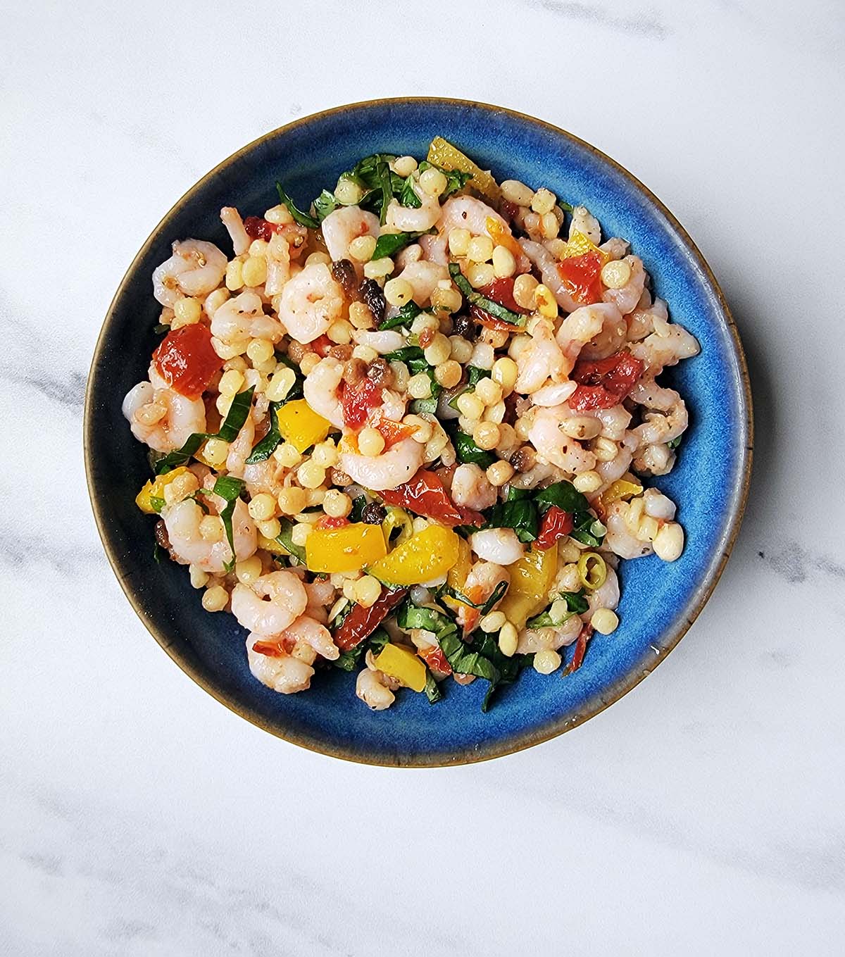 A summery shrimp pasta salad in a bowl. 