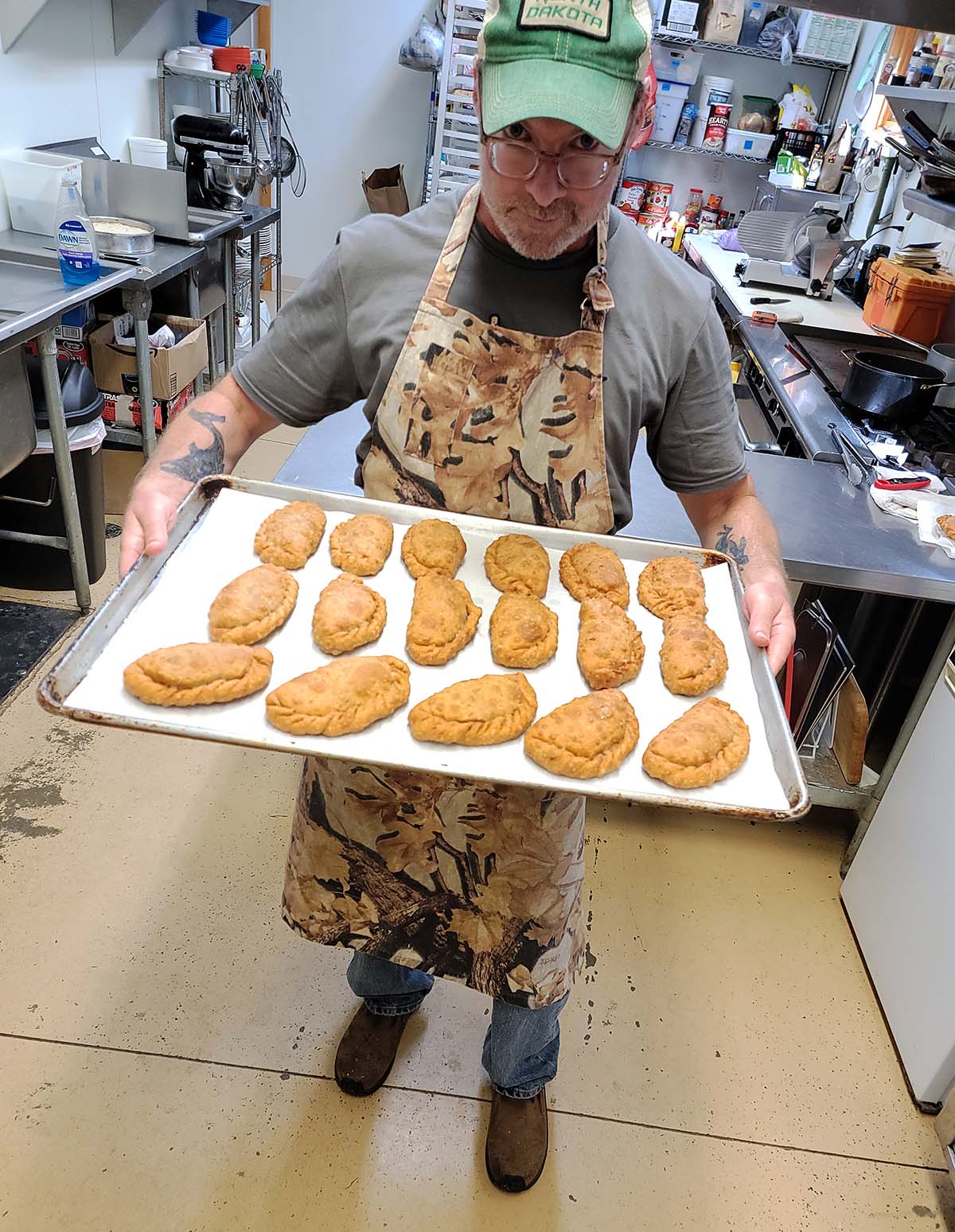 Hank holding a tray of meat pies. 