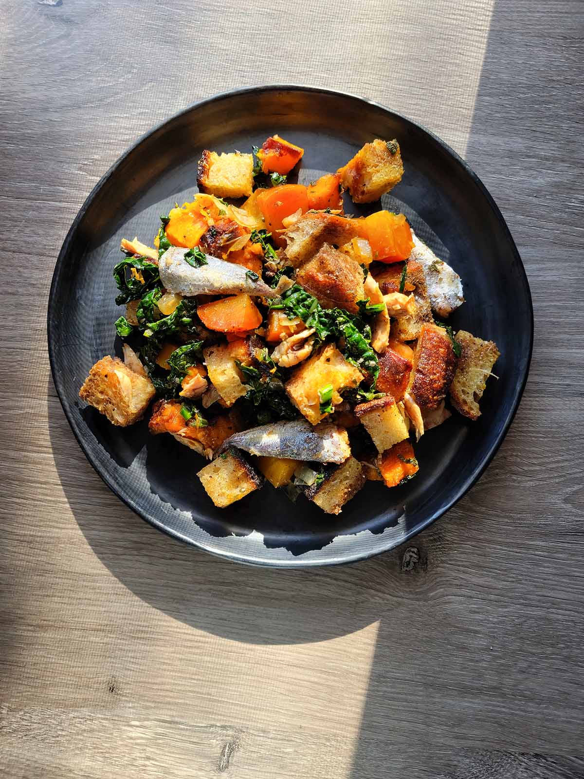 Winter panzanella on a plate in cool  light. 