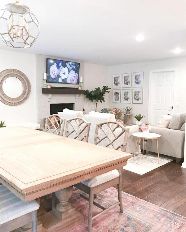 A beautiful open concept room with a dining table and sitting area with comfy chairs and a flat screen tv.