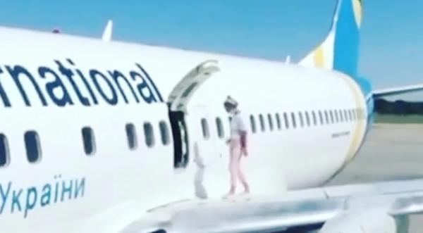 Woman On Plane Opens Emergency Exit & Walks Onto Wing As Her 2 Kids Watch