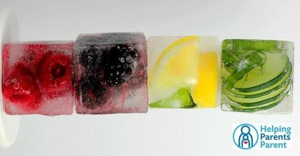 Ice cubes with fruit frozen in them (raspberries, blackberries, lemon slices, and cucumber slices)
