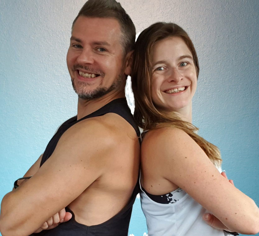 Two smiling YoZu trainers standing back to back with arms crossed