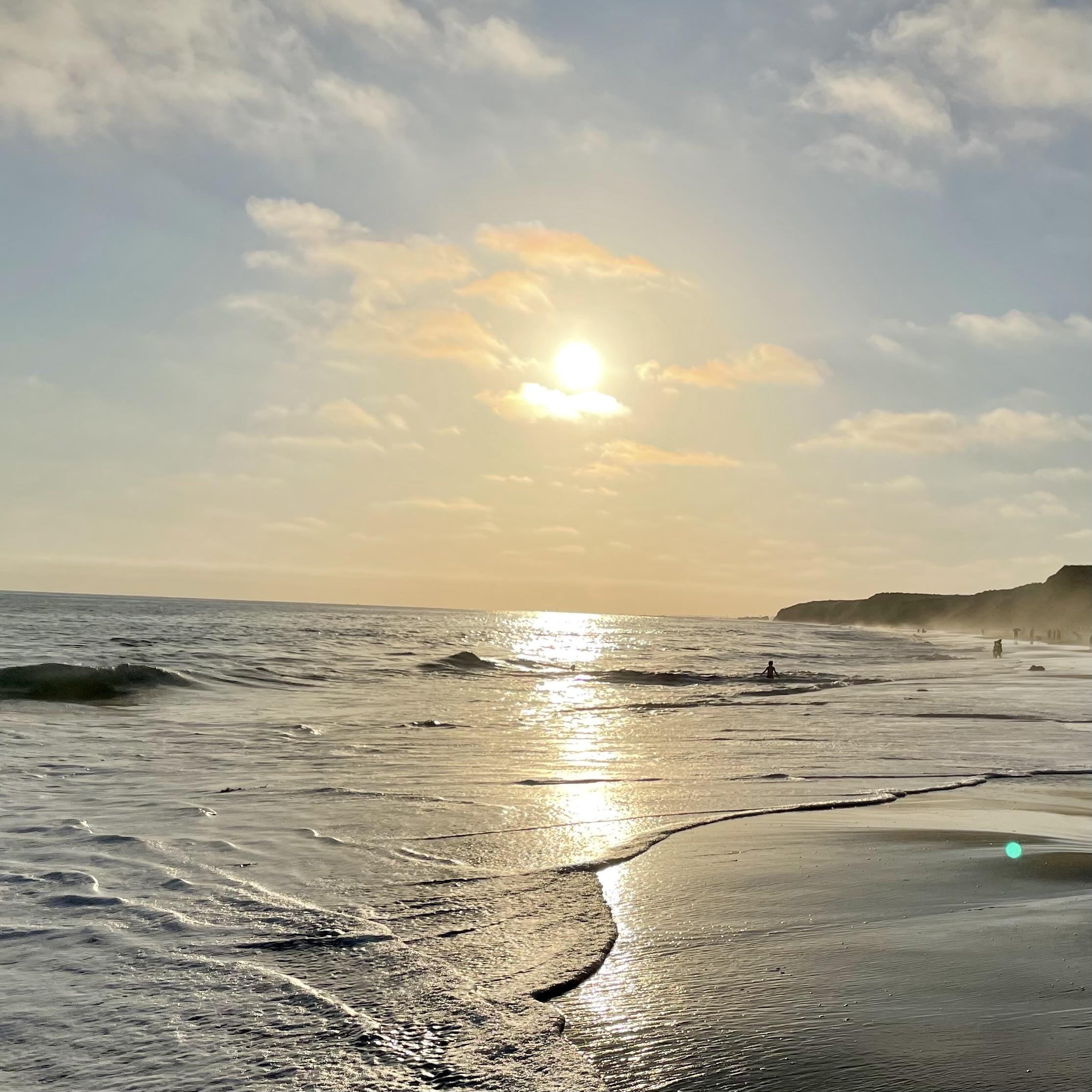 Beach sunset with golden light on waves