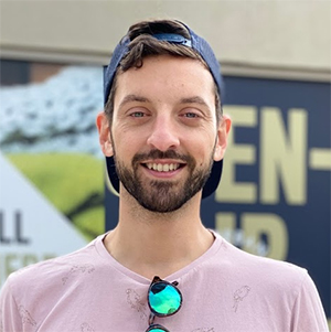 Chris smiling in a backwards cap and sunglasses
